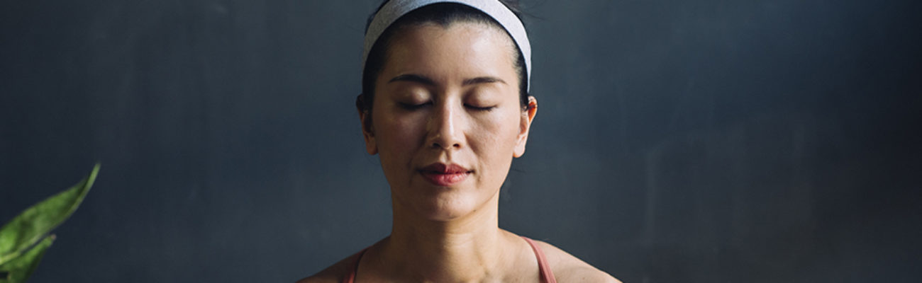 Woman meditating with eyes closed.