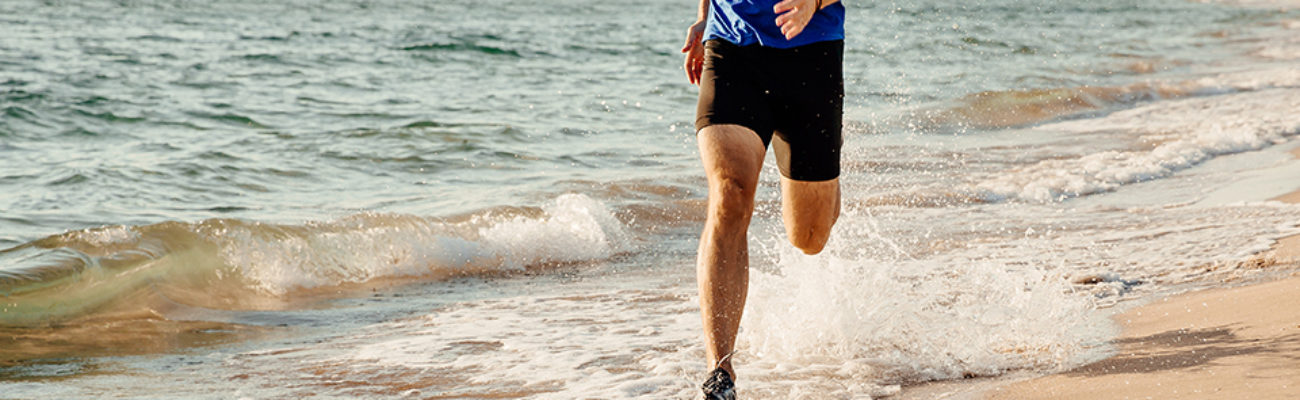 Man running in the water on the beach