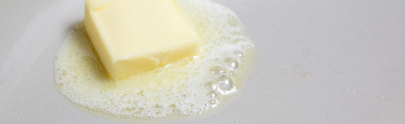 A tablespoon of butter melting in the pan.