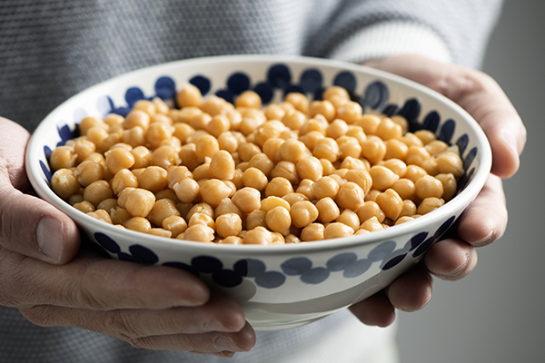 Hands holding a bowl of chickpeas