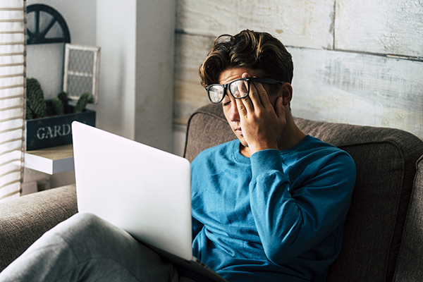 Sleepy man working on laptop