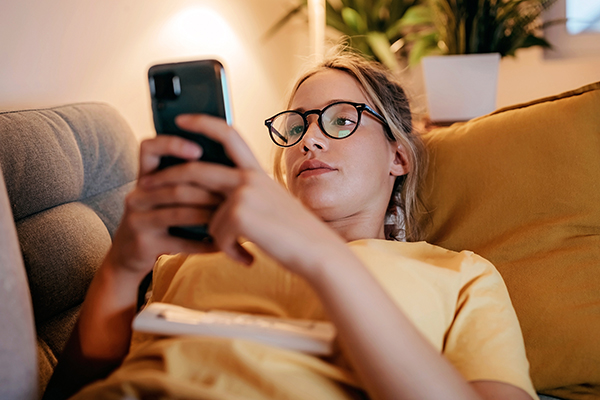 Woman lying on sofa looking at her phone