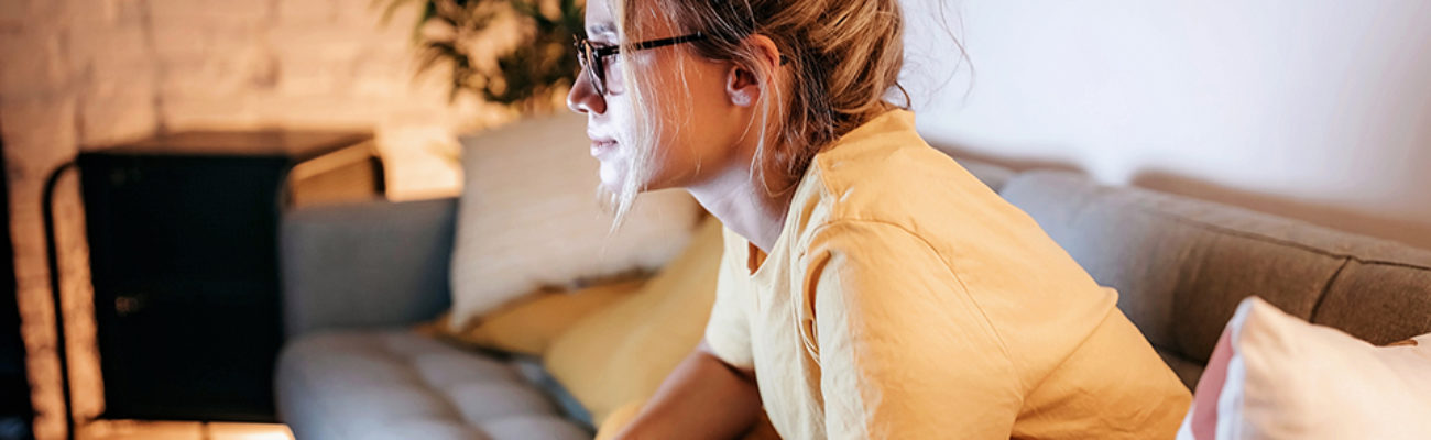 Woman sitting on sofa watching TV