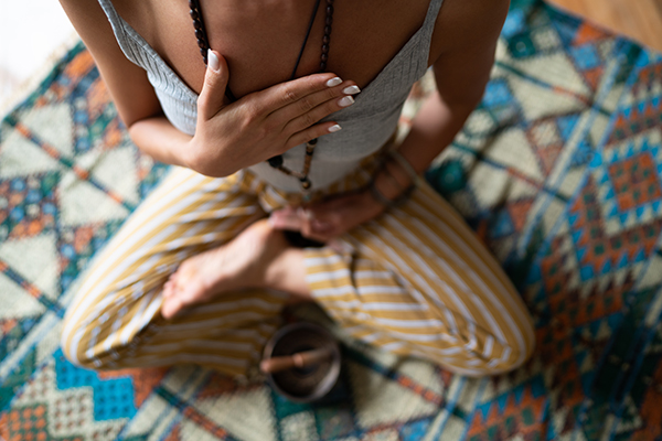 Close-up of a woman's hand on her chest while doing breathing exercises.