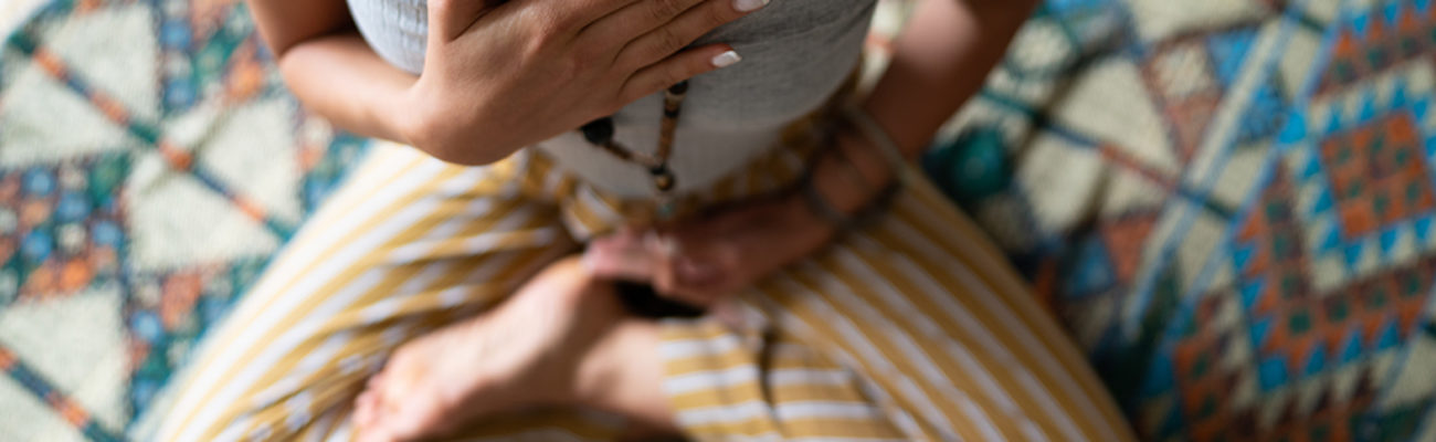 Close-up of a woman's hand on her chest while doing breathing exercises.