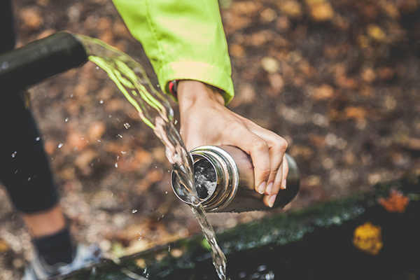 Closeup of woman's hand filling metal water bottle