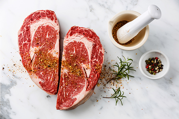 Seasoned raw steak on marble