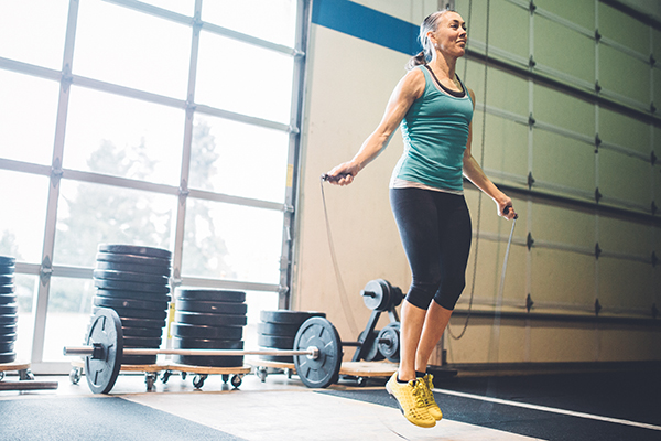 Older woman jumping rope in a gym