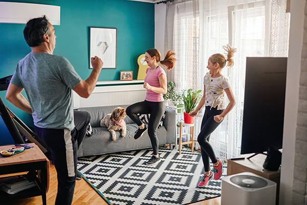 Father and two daughters exercising at home