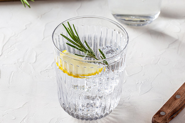 Glass of seltzer water with rosemary and lemon