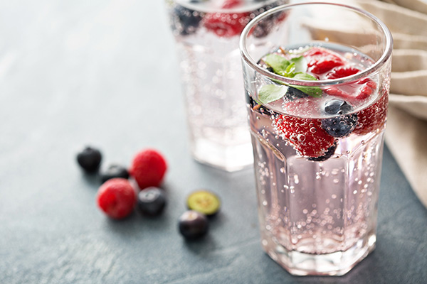 Glass of seltzer water with mint, raspberries and blueberries