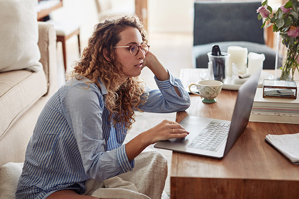 Woman looking at her laptop looking bored