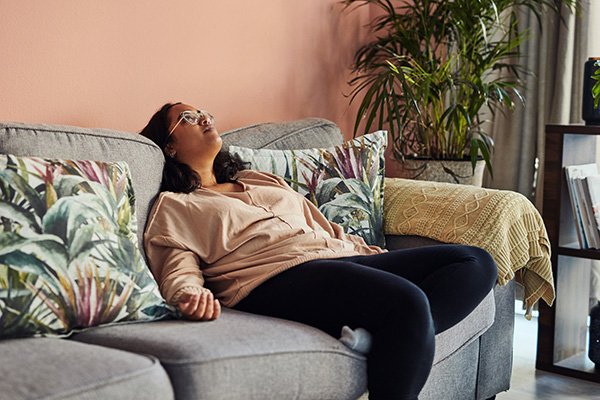 Unmotivated woman lying on couch