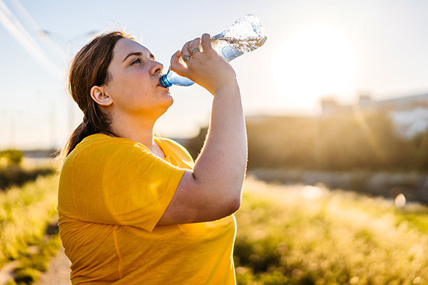 Woman drinking from water bottle outside