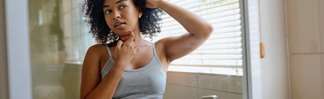 Woman checking skin in mirror