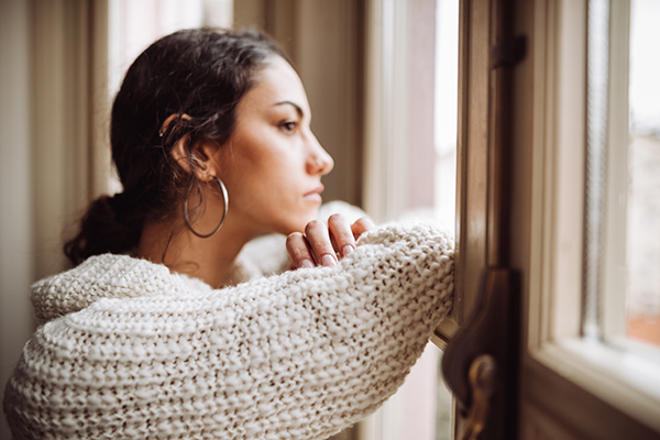 Woman looking out window, thinking