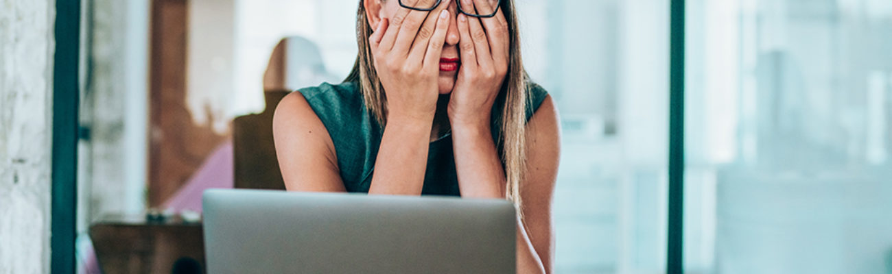 Stressed businesswoman with headache in the office.