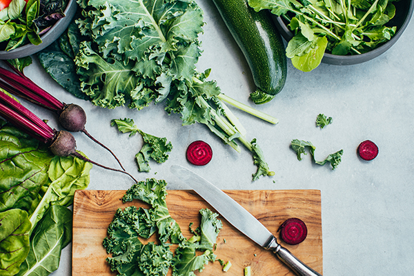 Kale, beets on wood chopping board