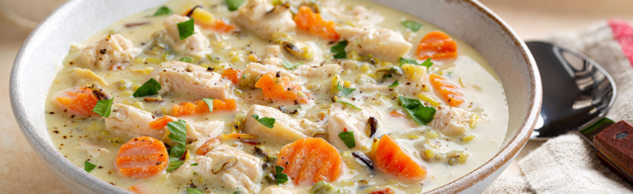 Closeup of a bowl of creamy chicken and rice soup.