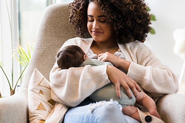 Mom breastfeeding baby in chair