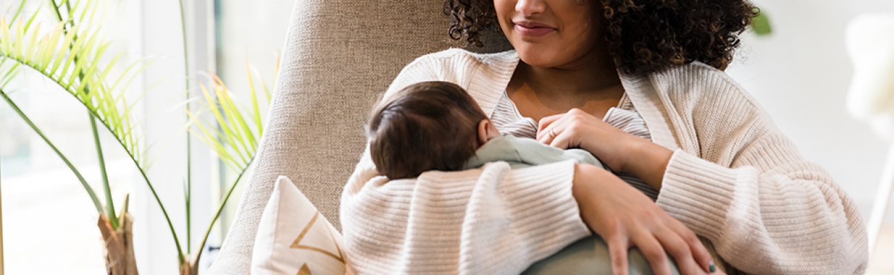 Mom breastfeeding baby in chair