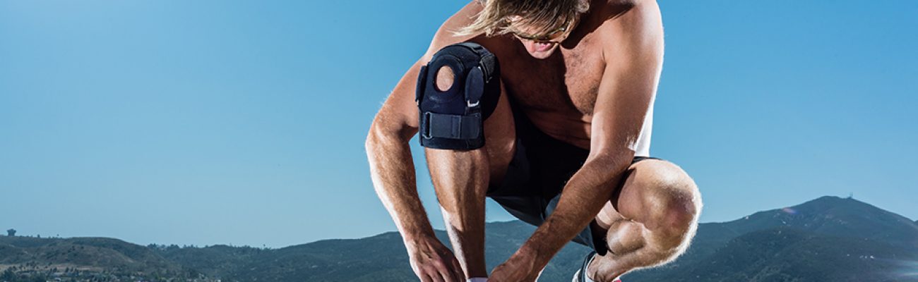 Runner Tying His Shoe With Knee Brace