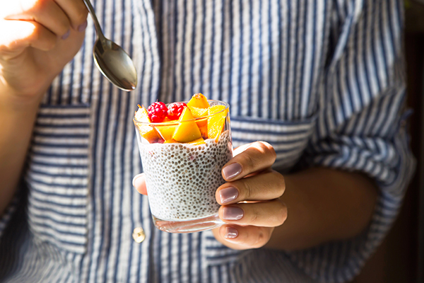 Chia pudding with raspberries and peach in a glass jar.