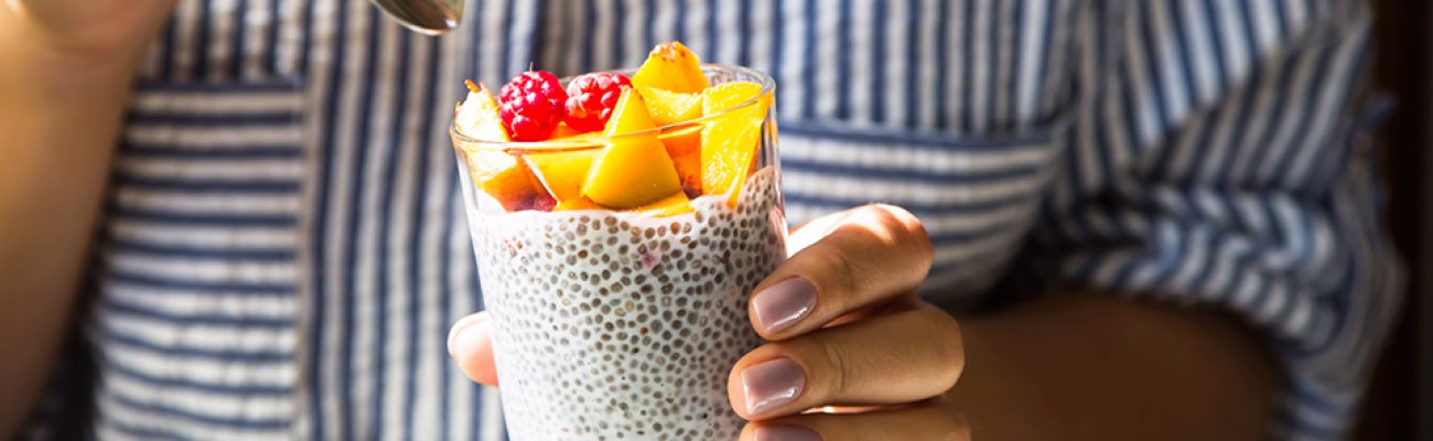 Chia pudding with raspberries and peach in a glass jar.