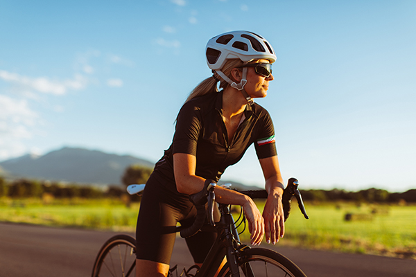 Female cyclist taking a break on a road