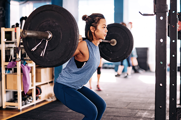 Woman lifting barbell at gym