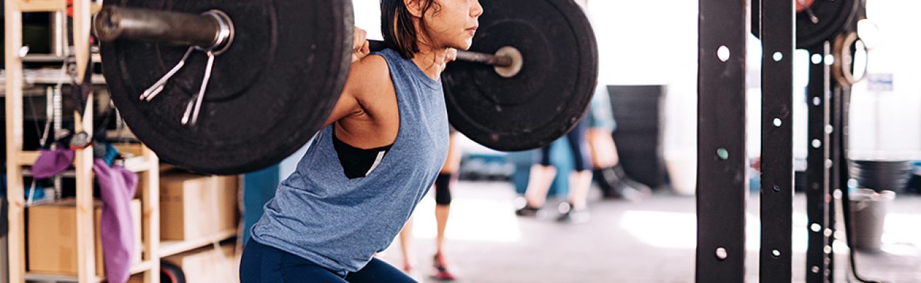 Woman lifting barbell at gym