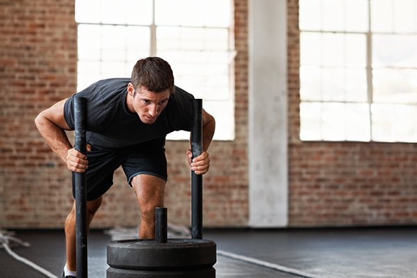 Man pushing sled at gym