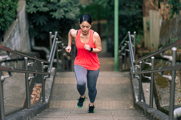 A young female athlete running up stairs