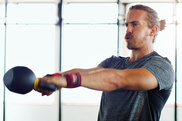 Man doing kettle bell swings