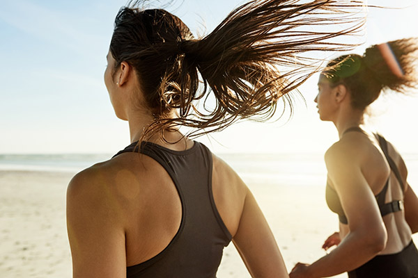 Two women running on the beach