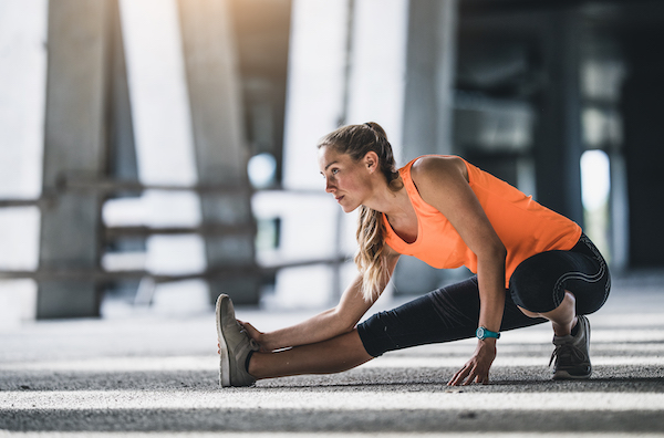 runner stretching outdoorss | nauseous after workout