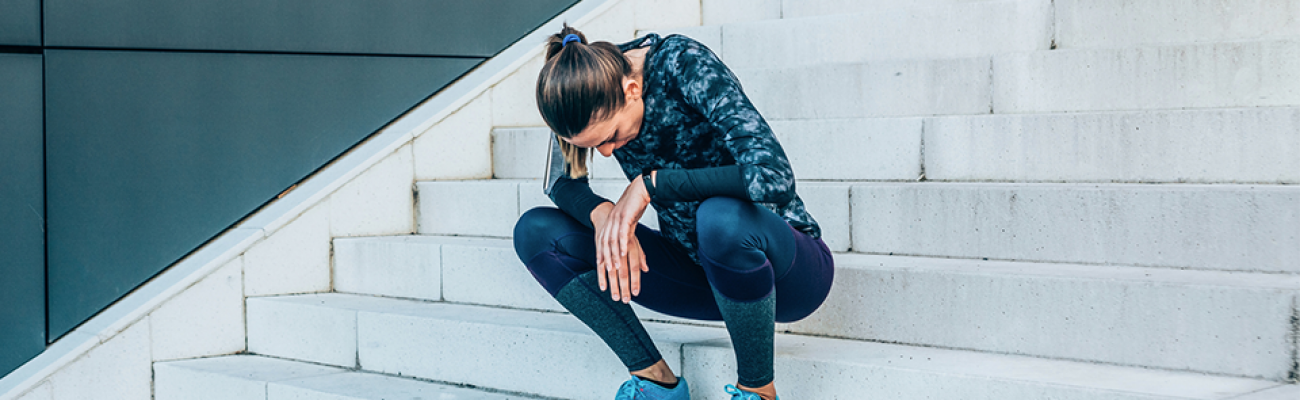 athlete resting on stairs | nauseous after workout