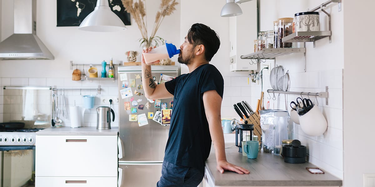 man drinking protein shake | do protein shakes make you fat