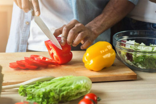 man cutting vegetables | meal plan for abs