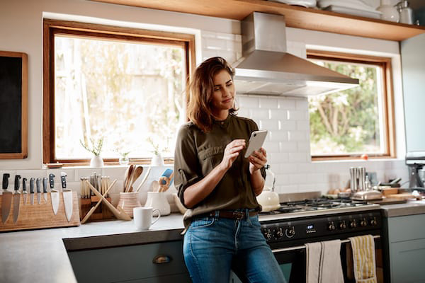 Woman texting in kitchen