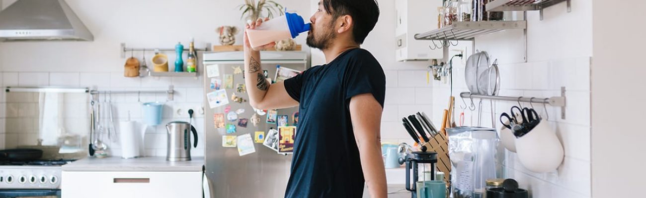 man drinking from bottle kitchen | how many protein shakes a day