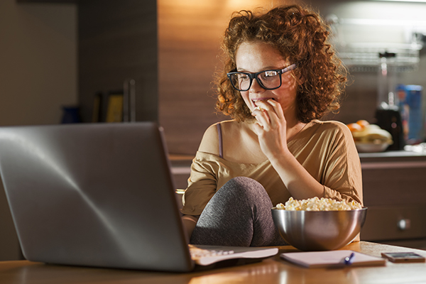 Woman snacking while on computer