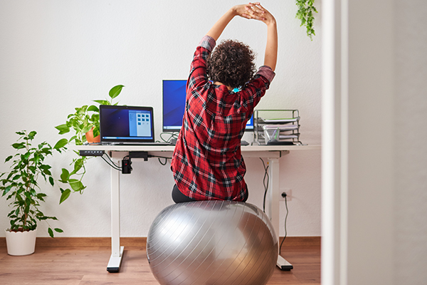 Woman sitting on stability ball chair at desk