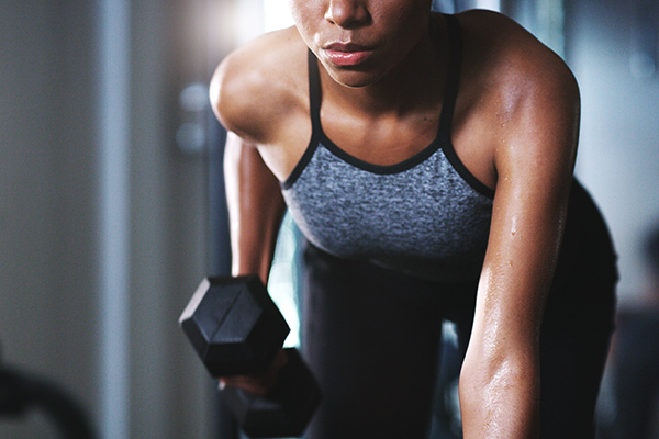 Cropped shot of women lifting dumbbell