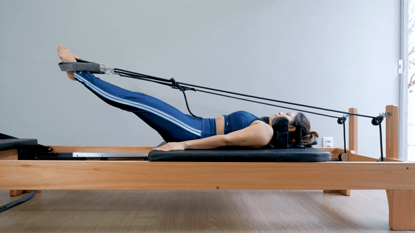 woman doing ab exercise in pilates reformer | Reformer Pilates