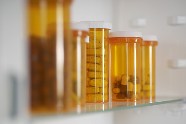 Bottles of pills in cabinet, close-up