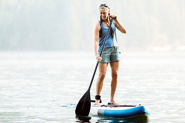 Mature woman paddleboarding on lake