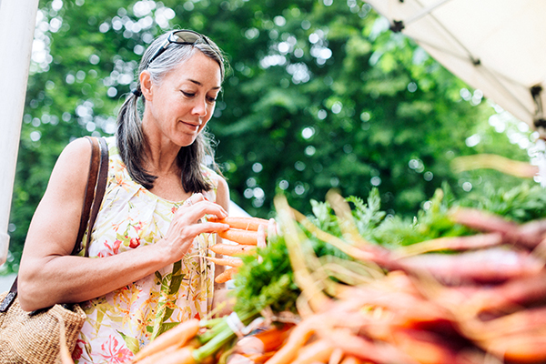 Woman buying vegetables at farmers' market