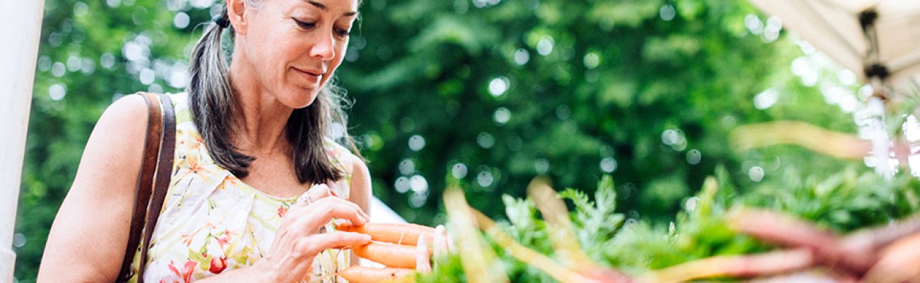 Woman buying vegetables at farmers' market