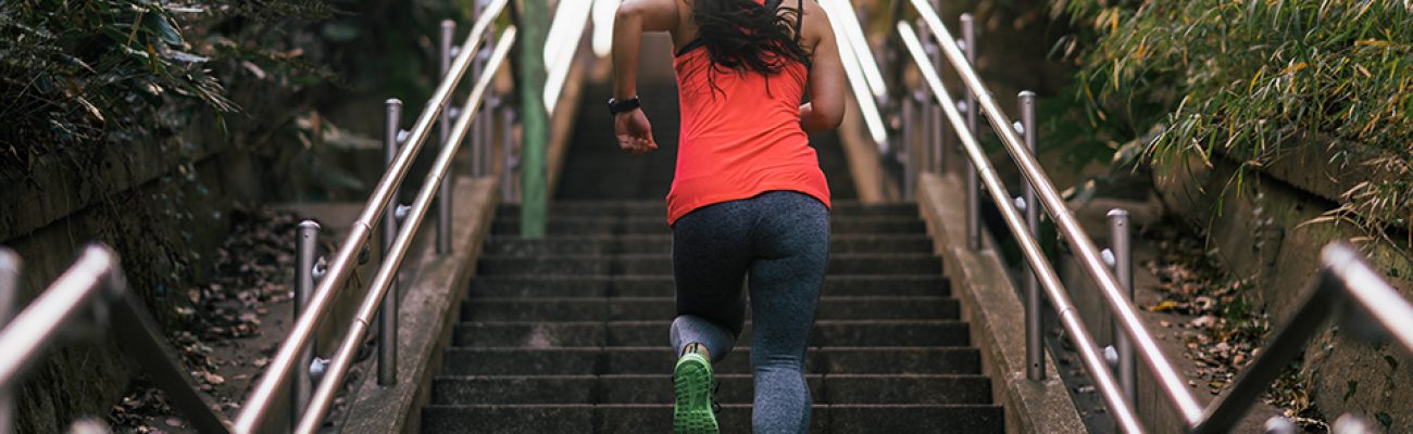 Female athlete running up stairs.